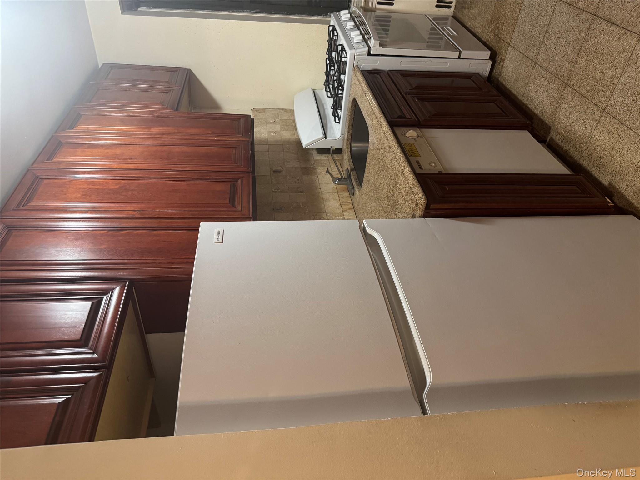 80-09 35th Avenue, Unit A12 Queens, NY 11372 - Photo 13 of 22 a kitchen with granite countertop stainless steel appliances and wooden cabinets
