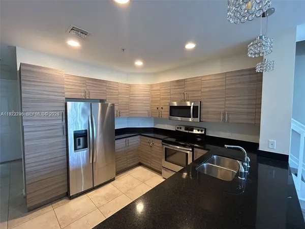 a kitchen with stainless steel appliances granite countertop a sink and cabinets