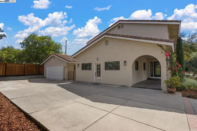 a view of a house with a small yard and a garden