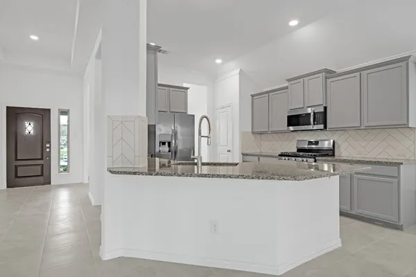 a kitchen with stainless steel appliances granite countertop a sink a stove a microwave a sink a refrigerator and cabinets