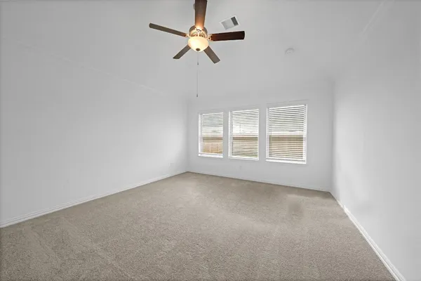 an empty room with fan and windows