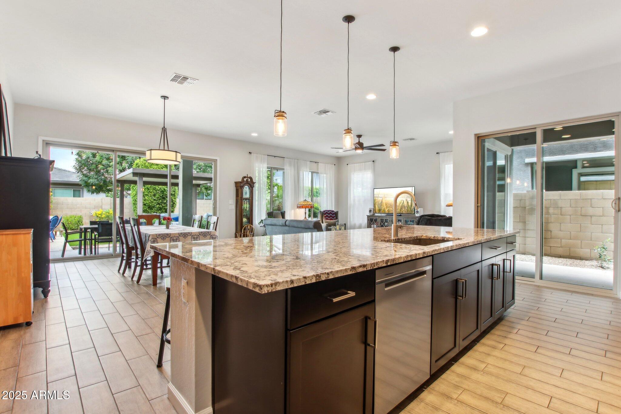 2942 East Appaloosa Road Gilbert, AZ 85296 - Photo 12 of 48 a kitchen with kitchen island granite countertop a table chairs and a chandelier