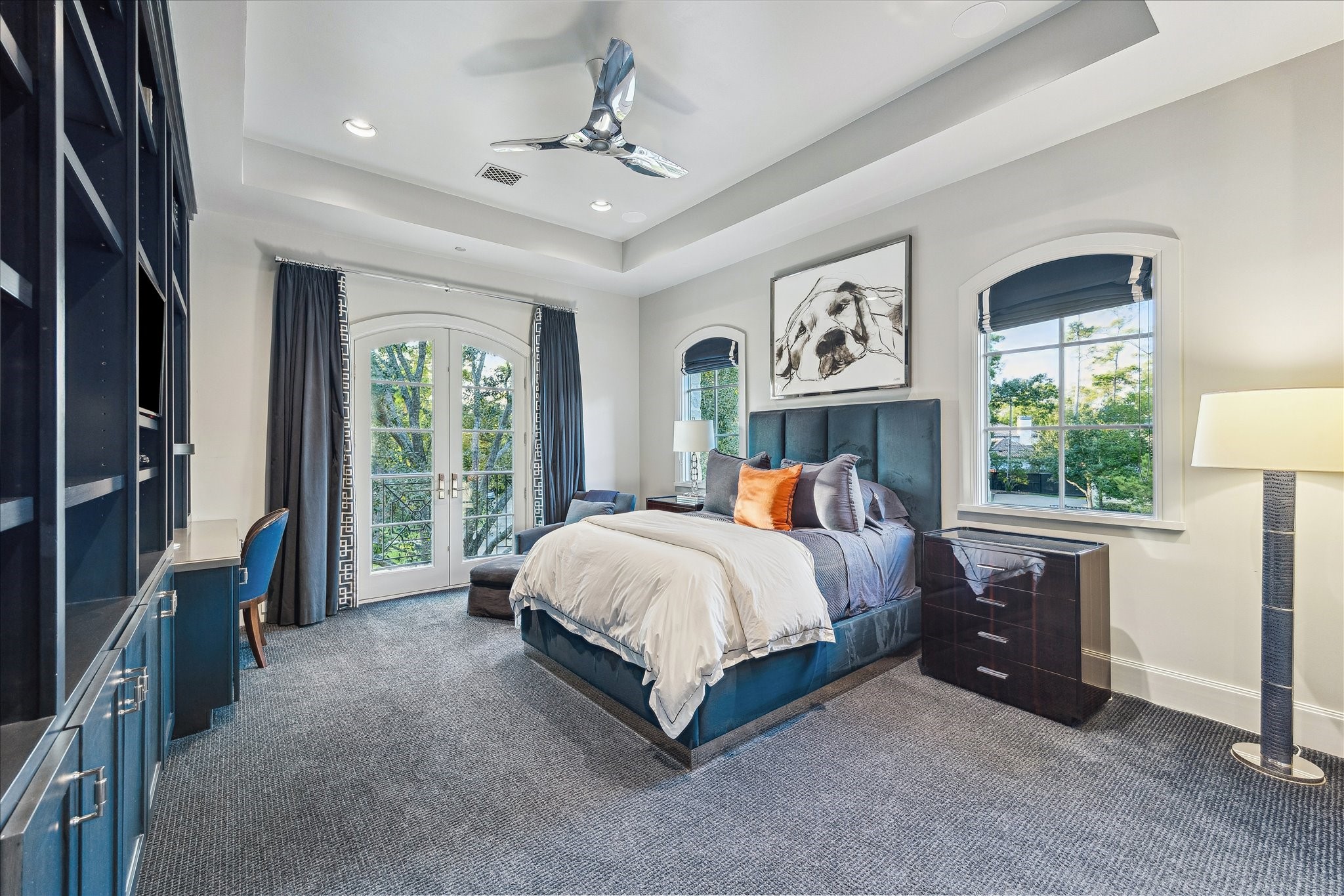 220 Merrie Way Lane Houston, TX 77024 - Photo 39 of 50 This bedroom features a built-in desk with generous storage, complemented by designer carpet flooring and a tray ceiling with recessed lighting. French doors open to a Juliet balcony overlooking the front lawn.