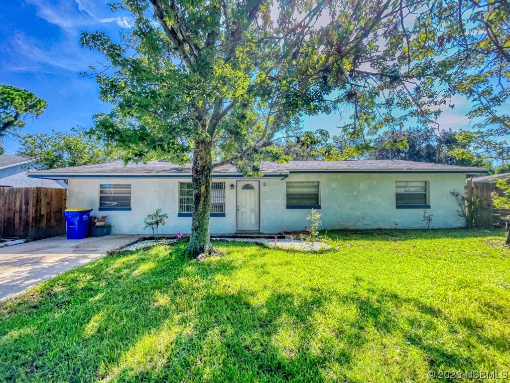 a view of a house with a yard and a tree