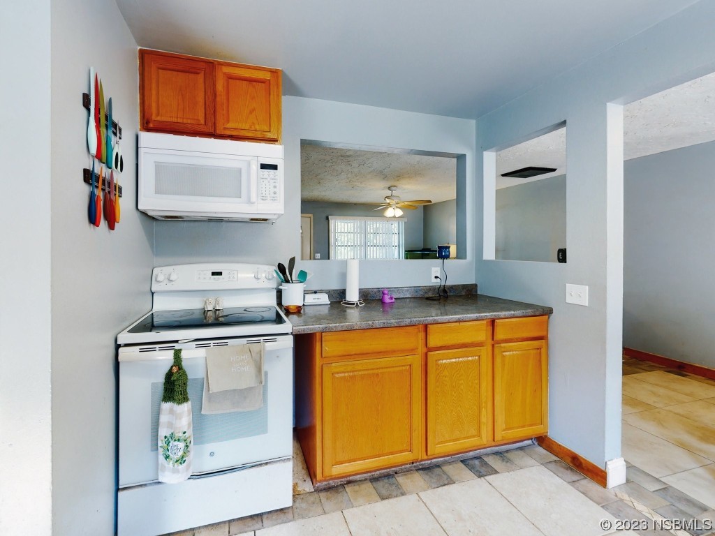 2761 Evergreen Drive Edgewater, FL 32141 - Photo 21 of 61 a kitchen with stainless steel appliances granite countertop a sink and a refrigerator