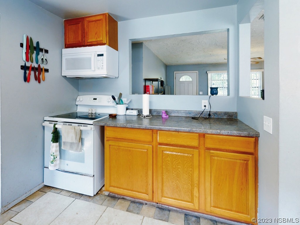 2761 Evergreen Drive Edgewater, FL 32141 - Photo 22 of 61 a kitchen with stainless steel appliances granite countertop a sink and a refrigerator