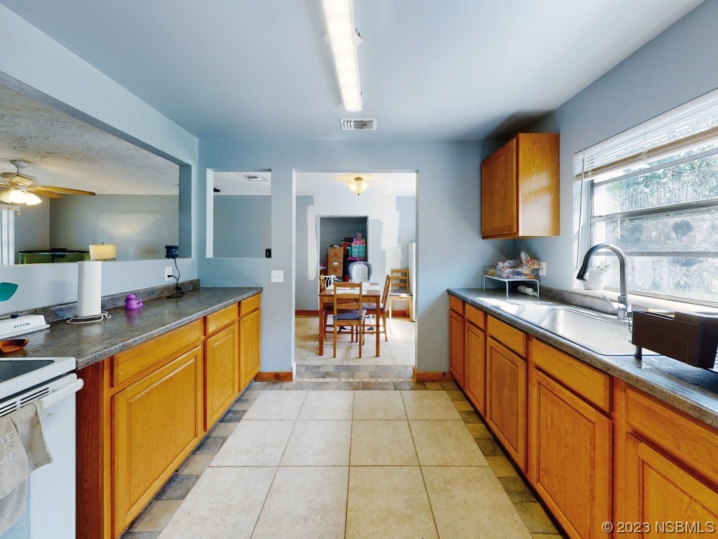 2761 Evergreen Drive Edgewater, FL 32141 - Photo 24 of 61 a large kitchen with stainless steel appliances granite countertop a sink counter space and a window