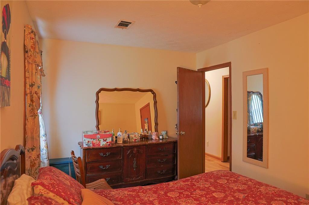 179 College Street Luthersville, GA 30251 - Photo 14 of 26 a bedroom with a bed and a mirror on dresser