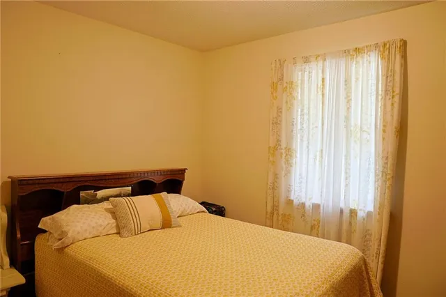 a bed sitting in a bedroom next to a window