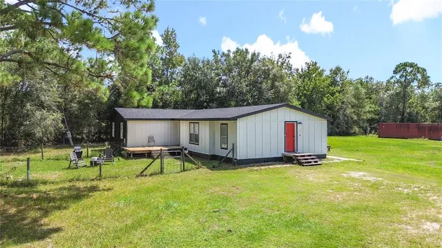 a view of backyard with table and chairs and potted plants