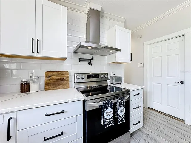 a kitchen with a stove and a chandelier