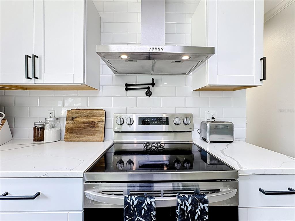 18604 Belvedere Road Orlando, FL 32820 - Photo 12 of 50 a kitchen with a stove and a chandelier