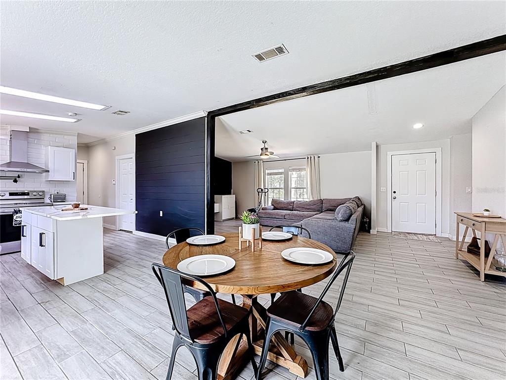 18604 Belvedere Road Orlando, FL 32820 - Photo 15 of 50 a view of a dining room with furniture and wooden floor