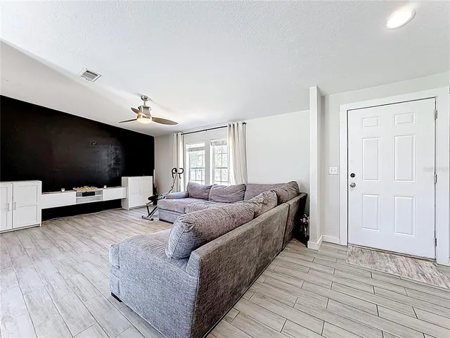 a spacious bedroom with a bed and ceiling fan