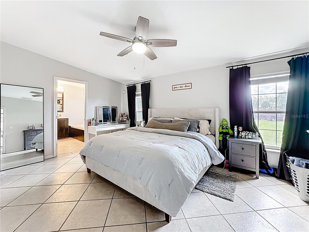 18604 Belvedere Road Orlando, FL 32820 - Photo 20 of 50 a spacious bedroom with a bed and ceiling fan