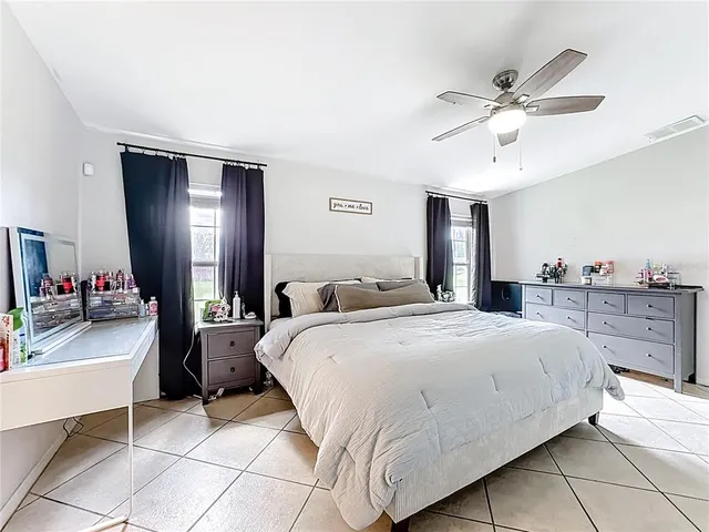 a large bedroom with a bed and a flat screen tv