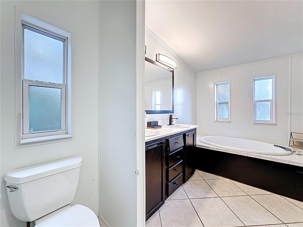 18604 Belvedere Road Orlando, FL 32820 - Photo 23 of 50 a bathroom with a sink a toilet and a mirror