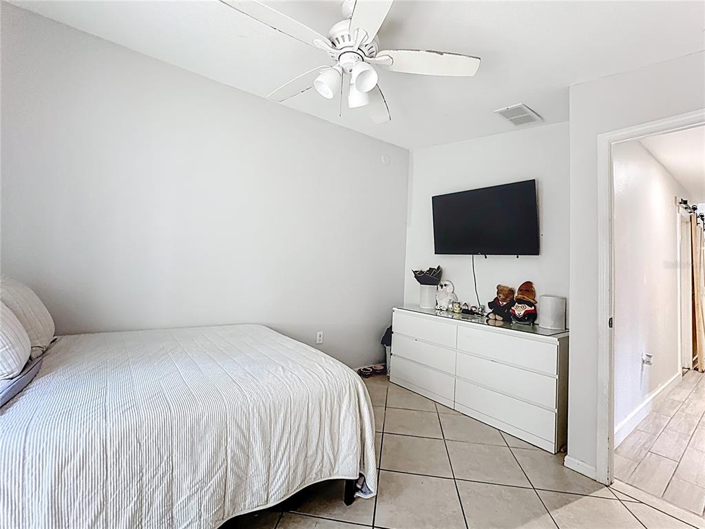 18604 Belvedere Road Orlando, FL 32820 - Photo 30 of 50 a bedroom with a bed and a flat screen tv