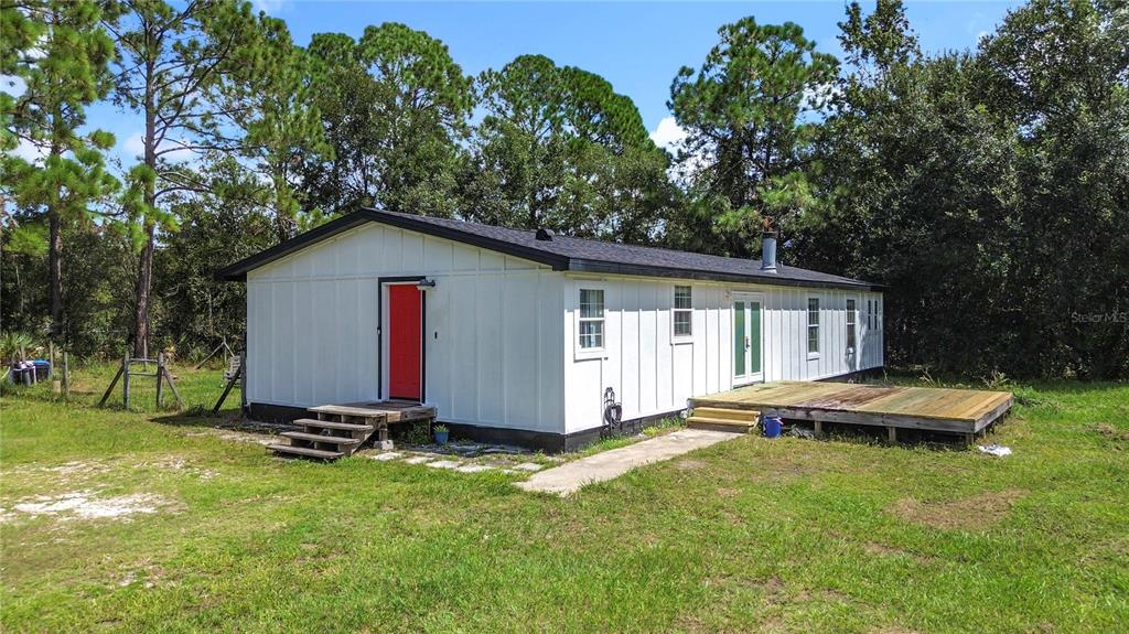 18604 Belvedere Road Orlando, FL 32820 - Photo 49 of 50 a view of backyard with wooden deck and seating area