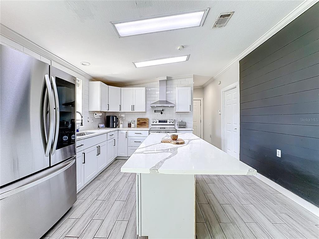 18604 Belvedere Road Orlando, FL 32820 - Photo 6 of 50 a kitchen with refrigerator cabinets and wooden floor