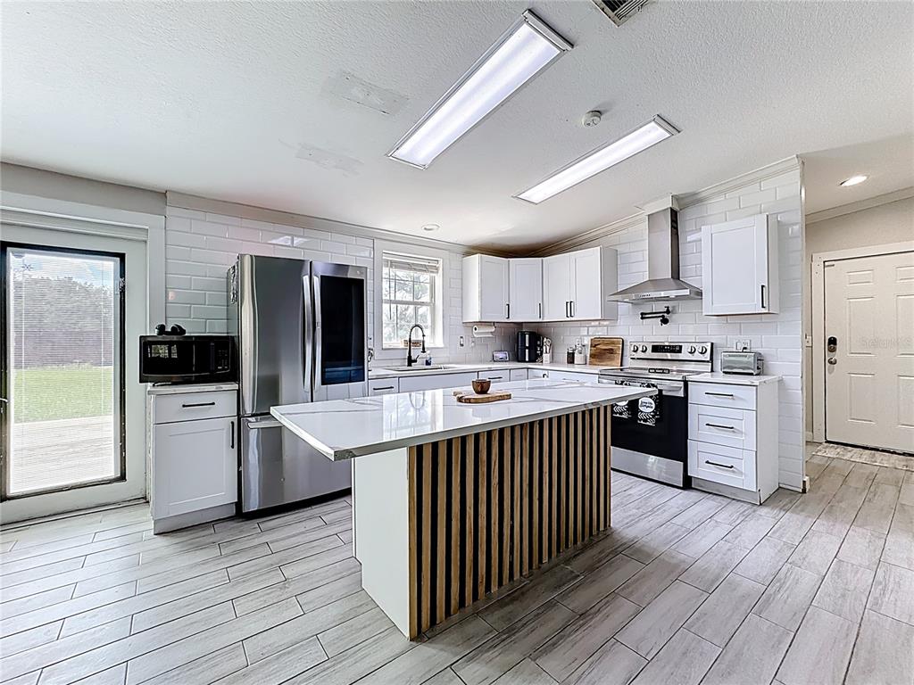 18604 Belvedere Road Orlando, FL 32820 - Photo 8 of 50 a kitchen with stainless steel appliances a refrigerator and a stove top oven