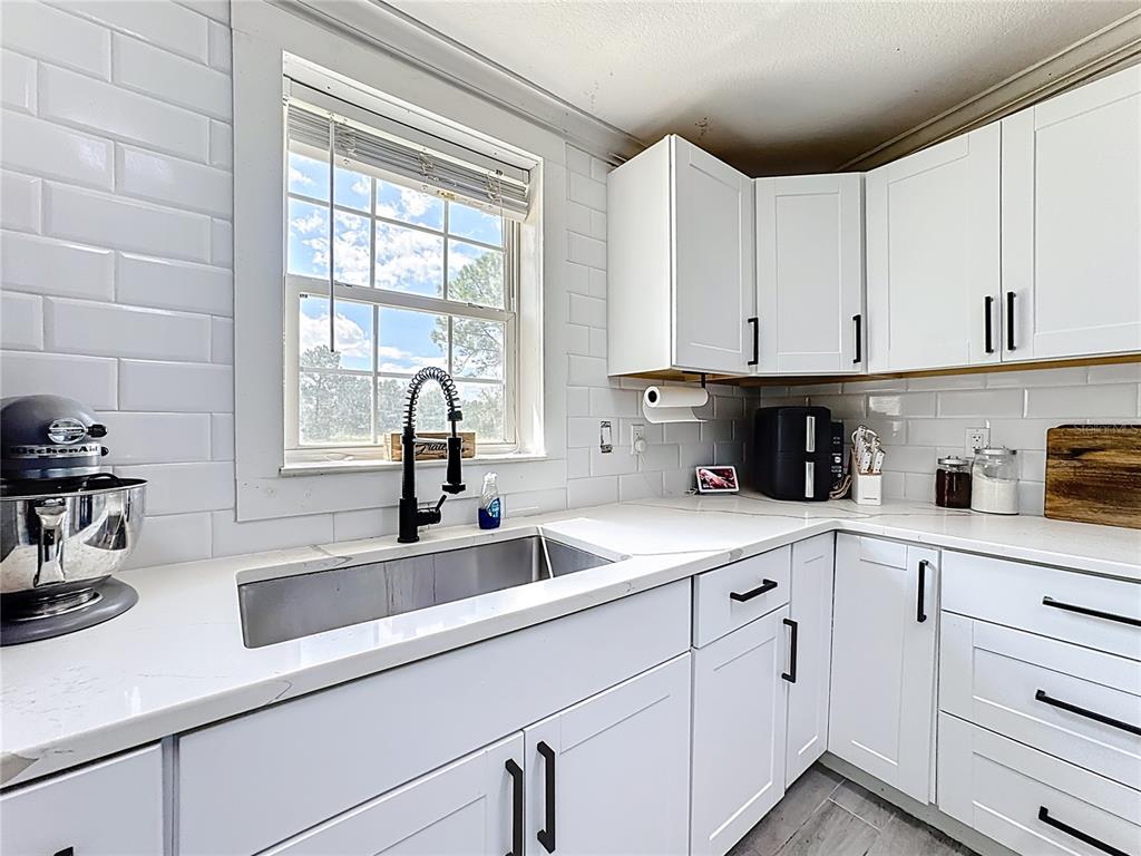 18604 Belvedere Road Orlando, FL 32820 - Photo 9 of 50 a kitchen with white cabinets and a sink