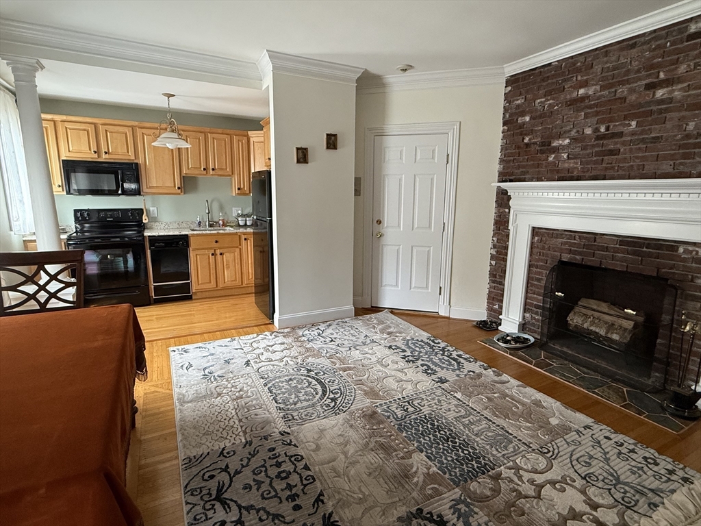 5 Porter Road, Unit 202 Andover, MA 01810 - Photo 6 of 17 a view of living room kitchen with granite countertop a fireplace and a window