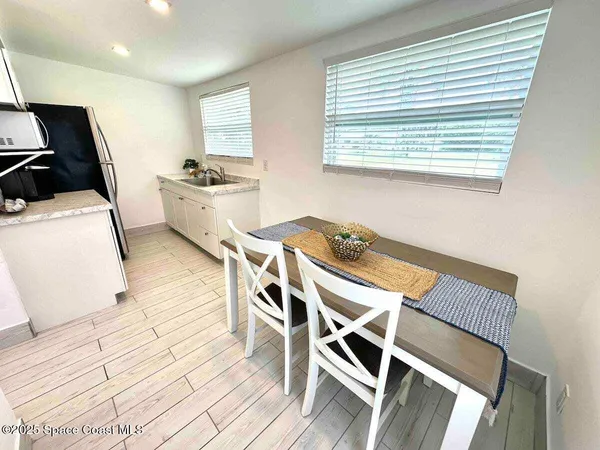 a kitchen with a table chairs a stove a refrigerator and cabinets
