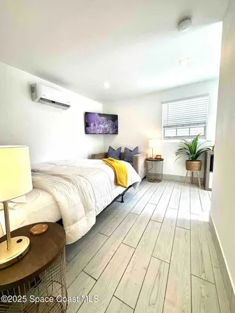 a bedroom with a bed and wooden floor