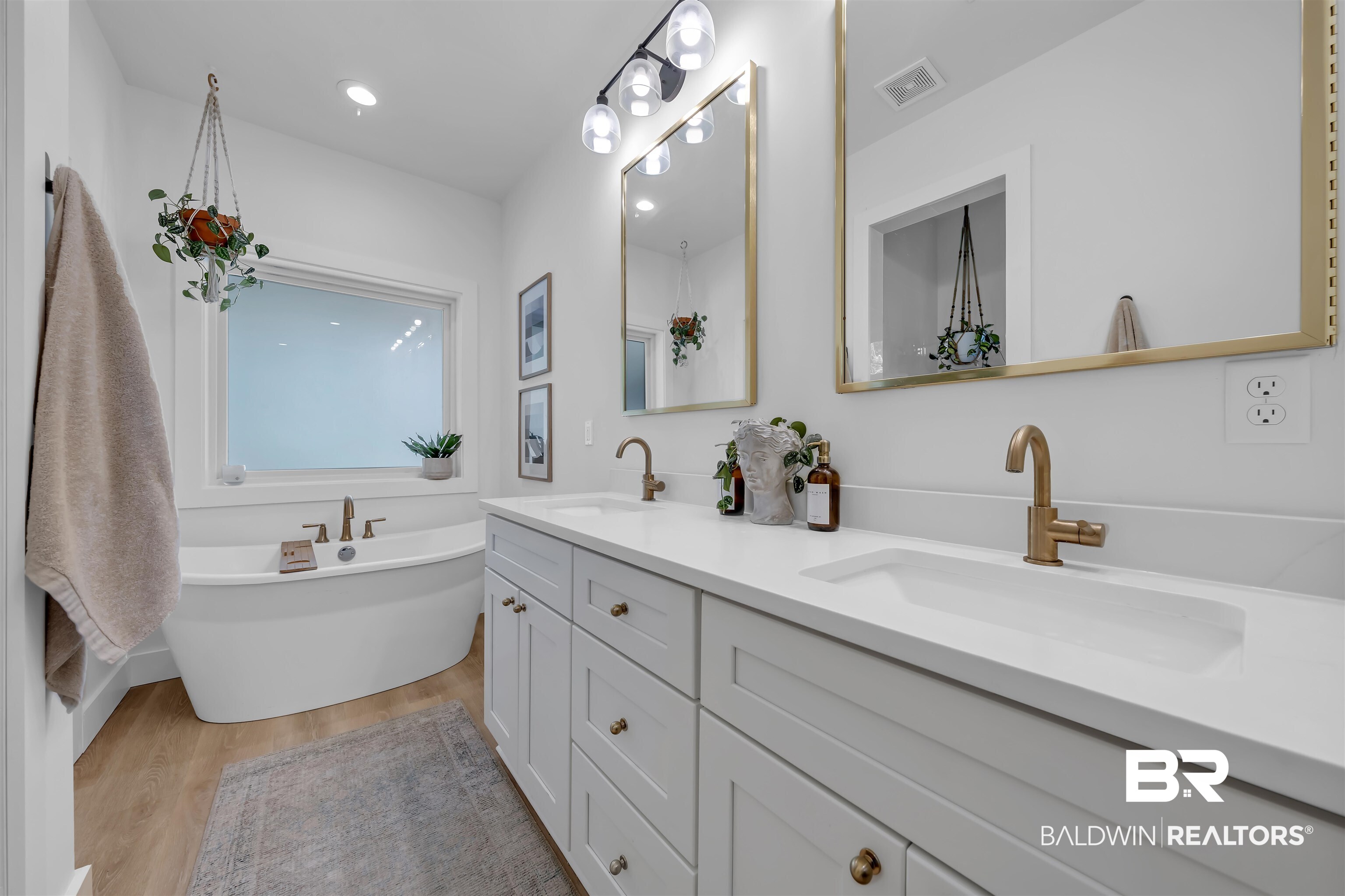 19058 James Road Gulf Shores, AL 36542 - Photo 24 of 49 Bathroom featuring double vanity, light wood finished floors, and a freestanding bath