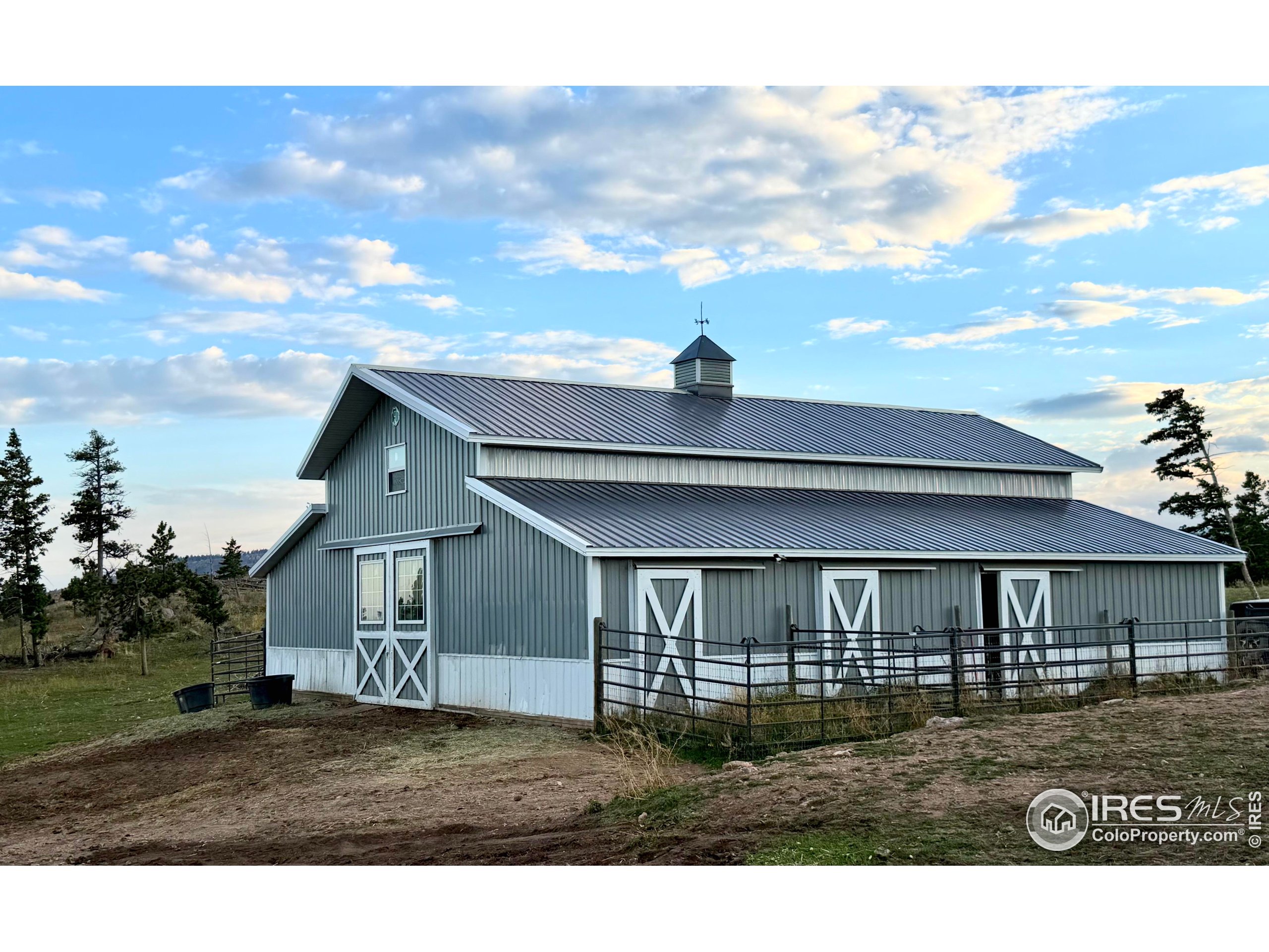 3235 Davis Ranch Road Bellvue, CO 80512 - Photo 22 of 38 a view of a yard in front of a house with large windows