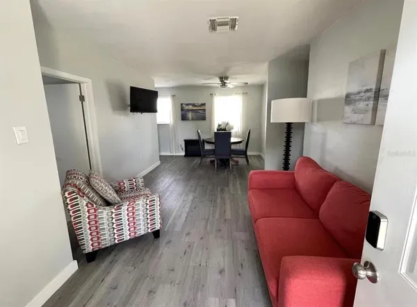 a living room with furniture and a wooden floor