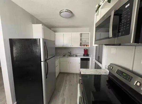 a kitchen with a refrigerator a stove top oven a sink and dishwasher