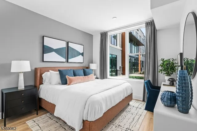 a bedroom with a bed a mirror and night stand