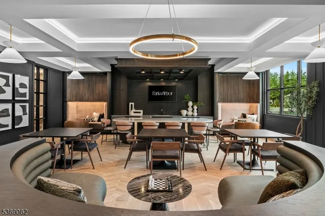 a living room with lots of furniture a large window and stainless steel appliances