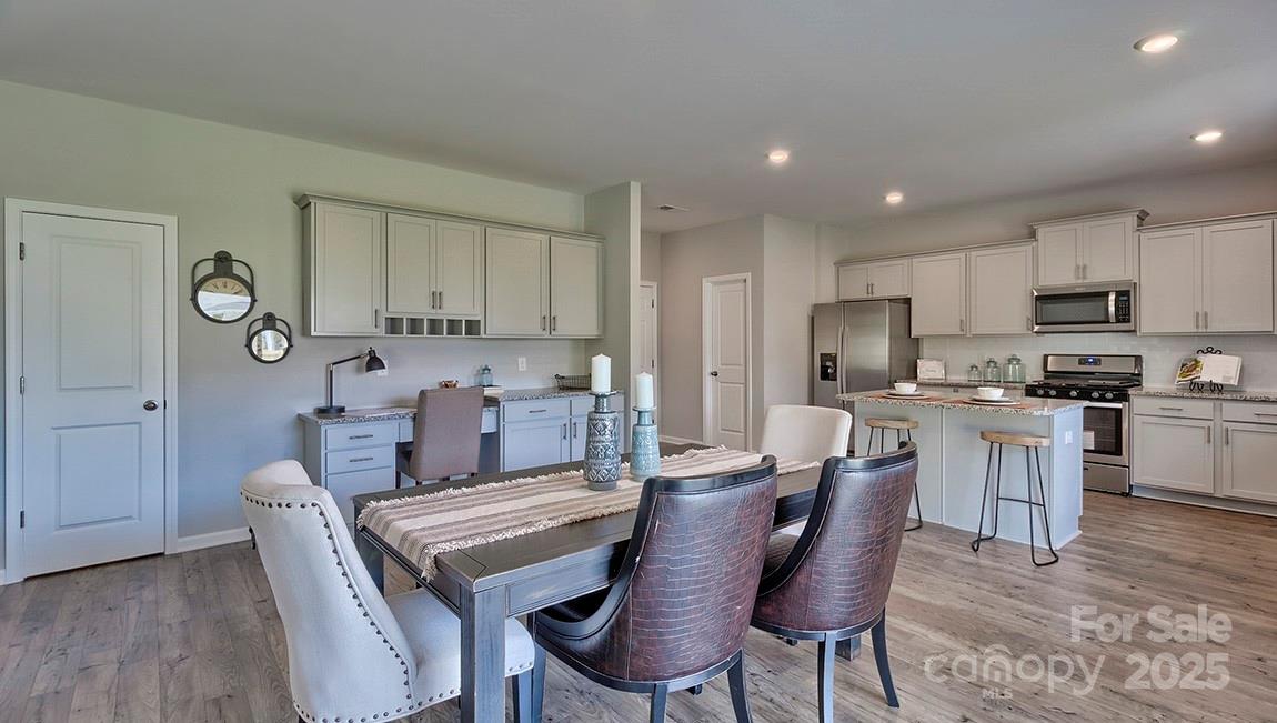 4025 Cramer Estates Gastonia, NC 28056 - Photo 11 of 36 a kitchen with granite countertop a dining table chairs and a refrigerator
