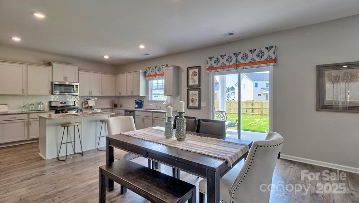 4025 Cramer Estates Gastonia, NC 28056 - Photo 12 of 36 a kitchen with a table chairs microwave and cabinets