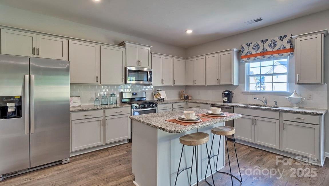 4025 Cramer Estates Gastonia, NC 28056 - Photo 15 of 36 a kitchen with stainless steel appliances granite countertop a sink stove refrigerator and cabinets