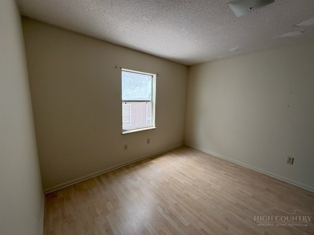 229 East King Street, Unit 31 Boone, NC 28607 - Photo 23 of 26 an empty room with wooden floor and windows