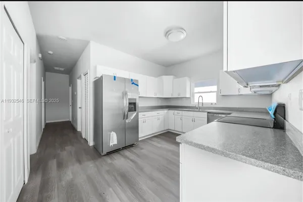 a kitchen with stainless steel appliances granite countertop a refrigerator and a sink