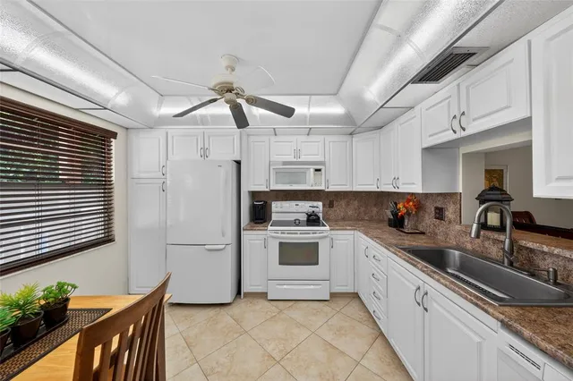 a kitchen with white cabinets and white appliances