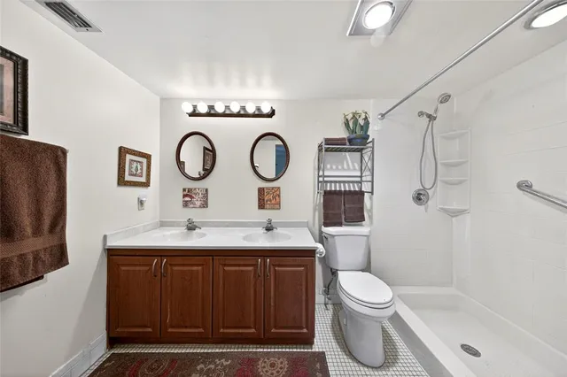 a bathroom with a granite countertop toilet sink and shower