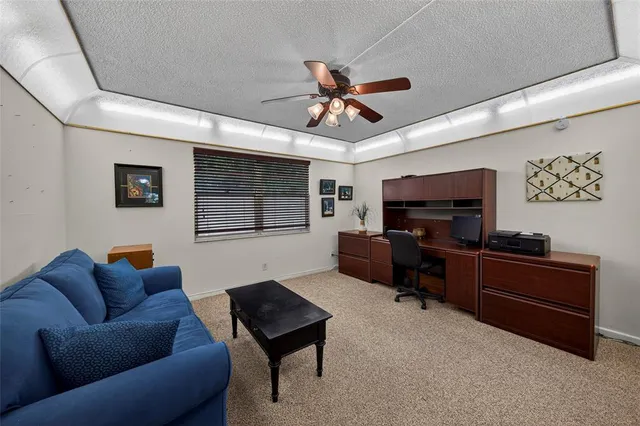 a living room with furniture a ceiling fan and a window
