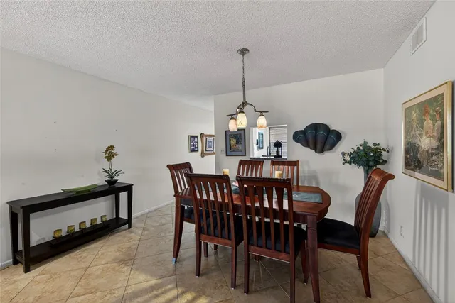 a view of a dining room and a livingroom with furniture wooden floor a chandelier