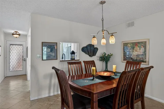a dining room with furniture a potted plant and a chandelier