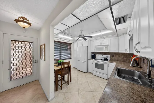 a kitchen that has a lot of cabinets in it and appliances