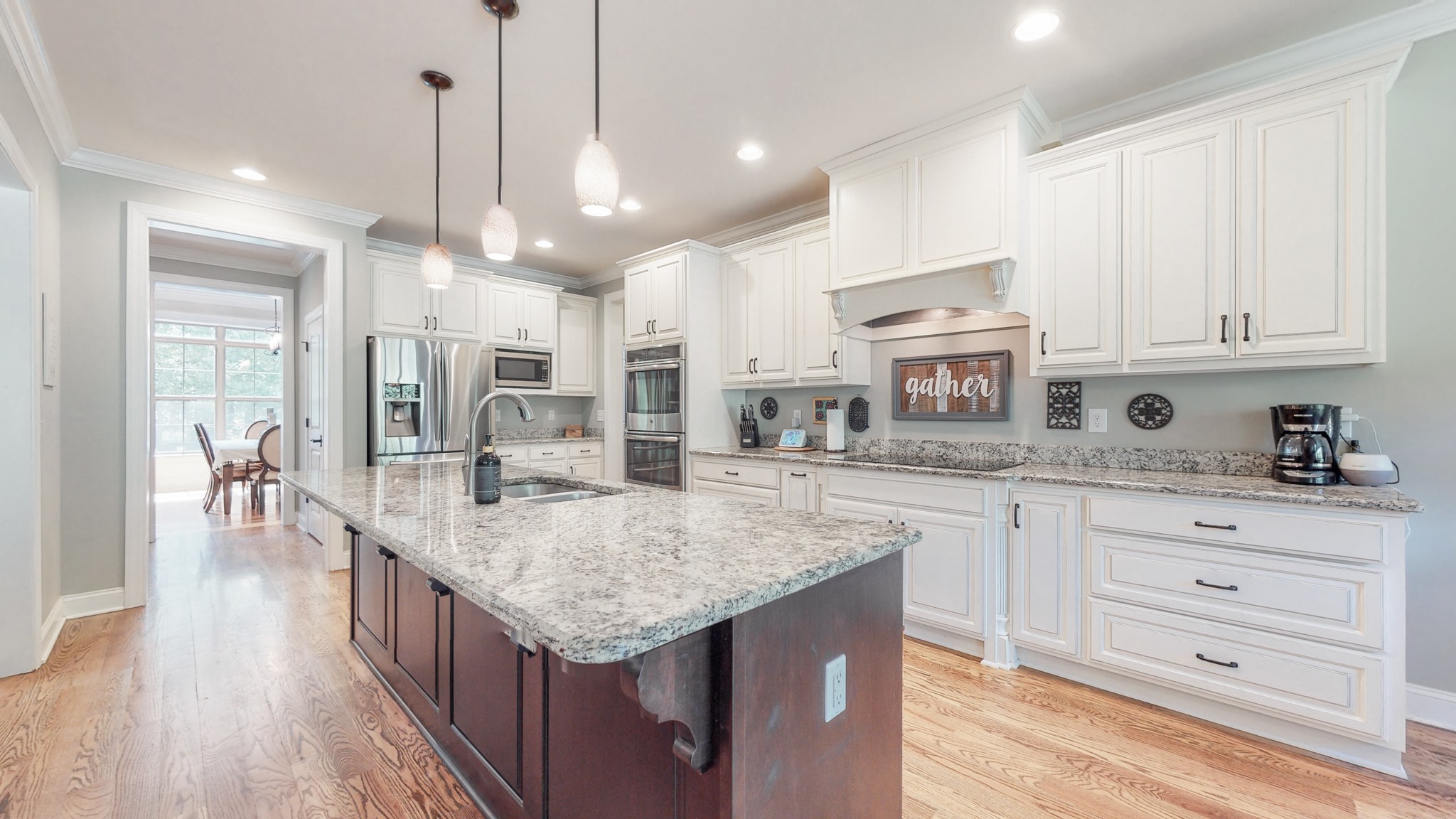 7270 Old Franklin Road Fairview, TN 37062 - Photo 15 of 46 a kitchen with granite countertop a stove a sink dishwasher and white cabinets with wooden floor
