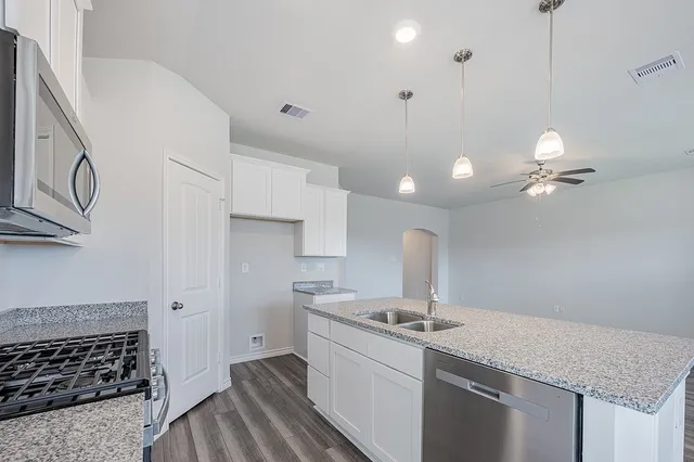 a kitchen with a sink stove and cabinets