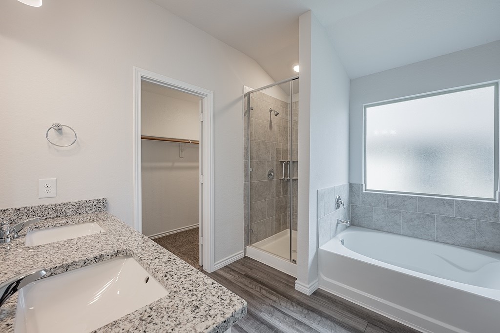 1101 Davy Street Brenham, TX 77833 - Photo 10 of 18 a bathroom with a granite countertop sink a mirror and a bathtub