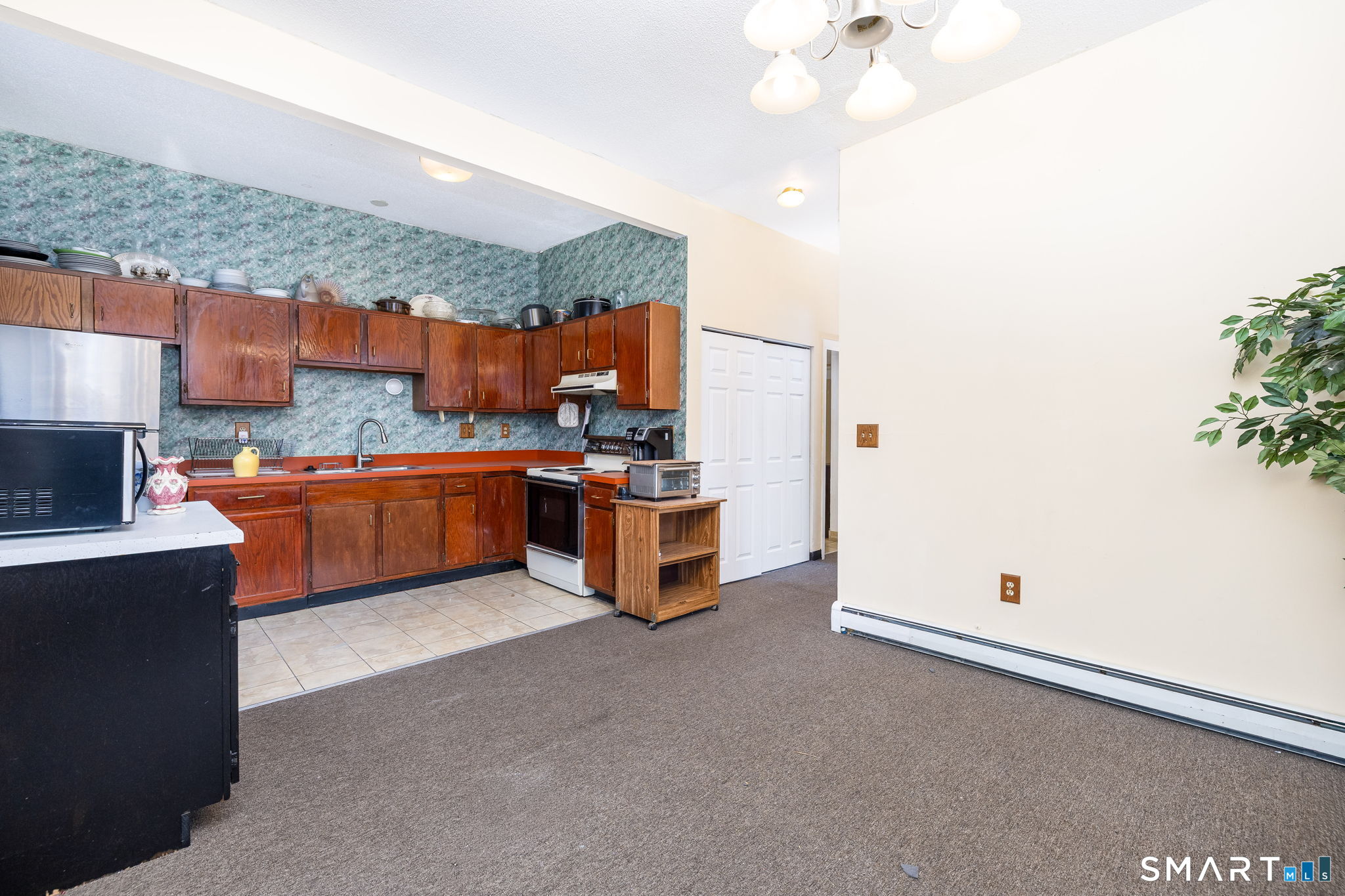 36-38 Capen Street, Unit 2B Hartford, CT 06120 - Photo 10 of 25 a kitchen with stainless steel appliances a stove a sink a refrigerator and chairs